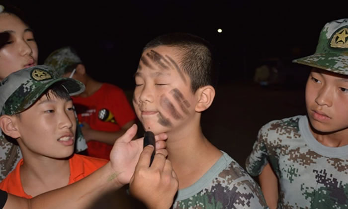 軍事夏令營中孩子們在互相涂抹油彩
