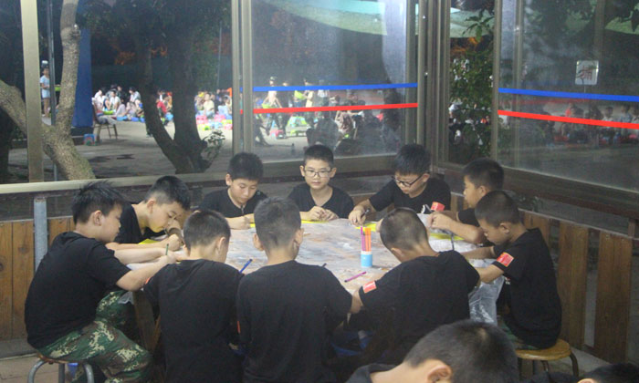 孩子在桌上的黃紙上畫(huà)上自己的想象