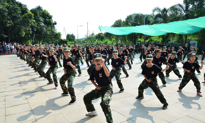 家長們在后面看孩子軍事演練